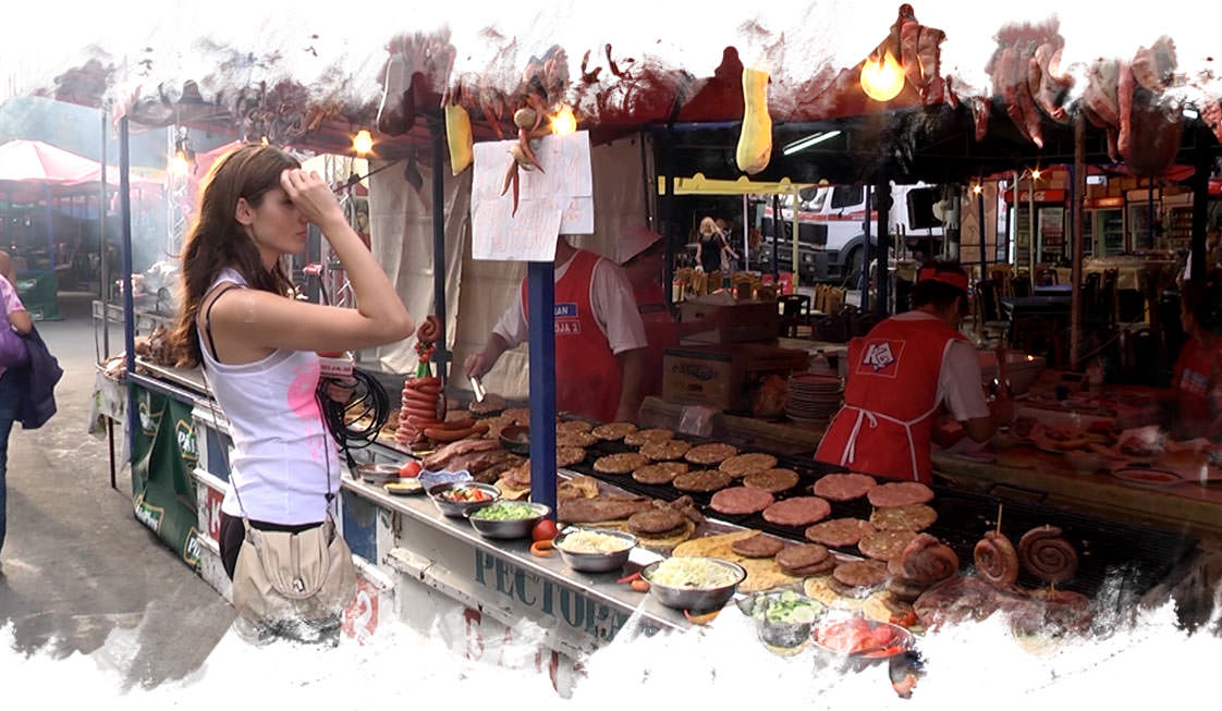 Girl standing in market deciding what to eat.